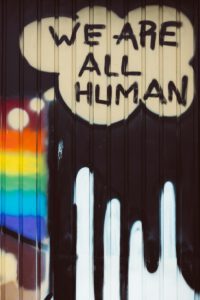 we are all human written on the side of a building