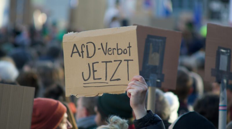 a person holding a cardboard sign in front of a crowd