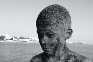 sculpture, sad boy, nature, burned, face, thinking, sad, figure, remorse, thoughtful, boy, man, black, white, broken, metal, bronze, sea, seascape, paphos, cyprus, statue, deformed, mutilated, gray think, gray metal
