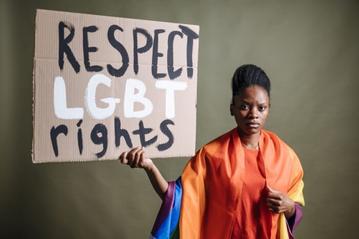Portrait of a woman holding a sign promoting LGBT rights, activist stance.