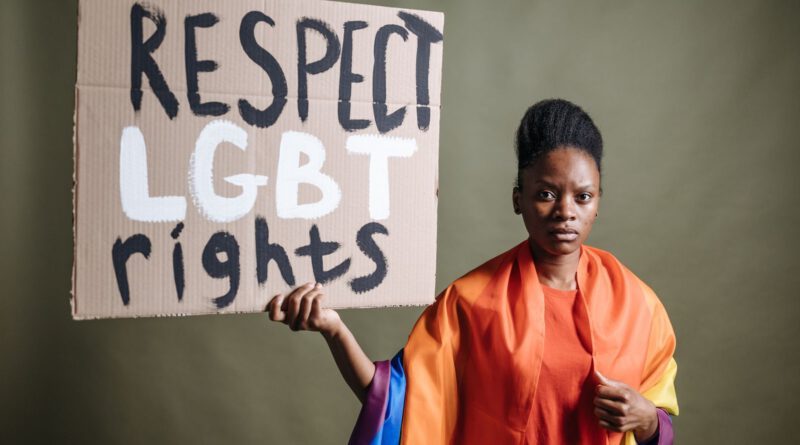 Portrait of a woman holding a sign promoting LGBT rights, activist stance.