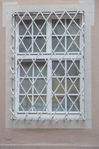 a white window with bars on the side of it